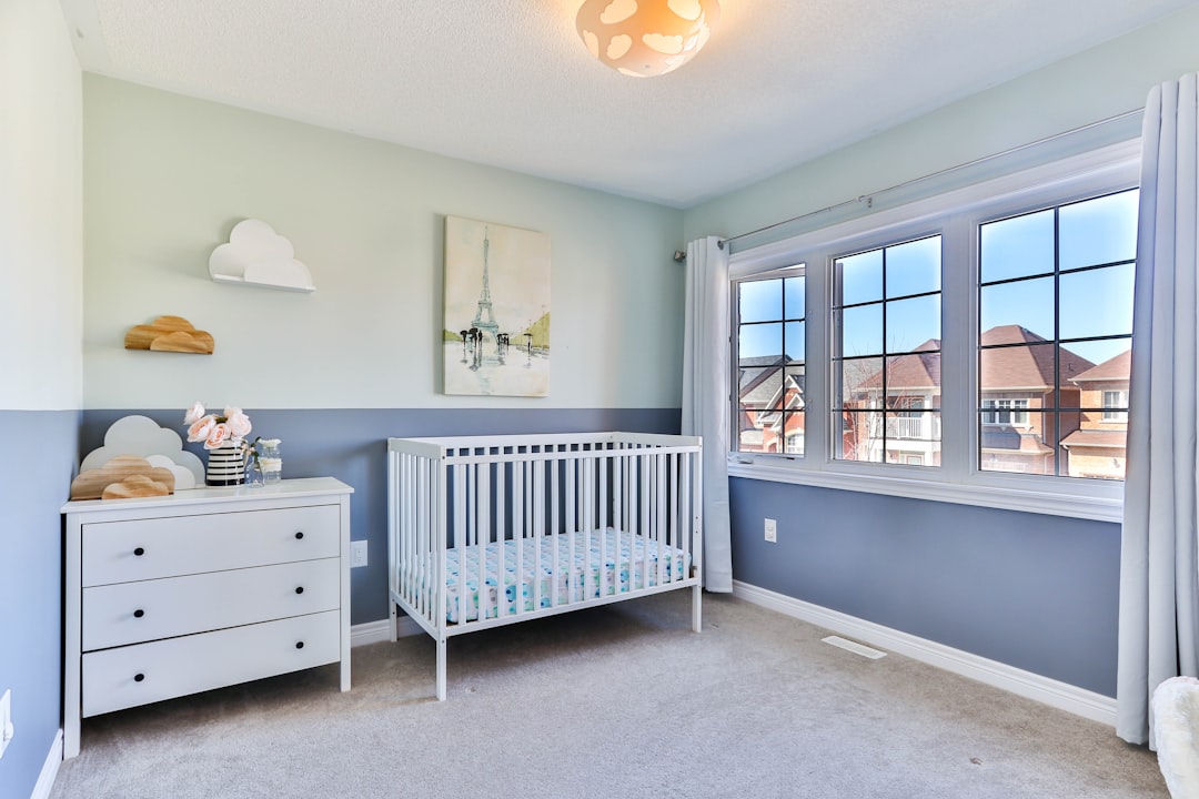 A cozy and safe nursery with soft colors, a crib, and childproofing elements.
